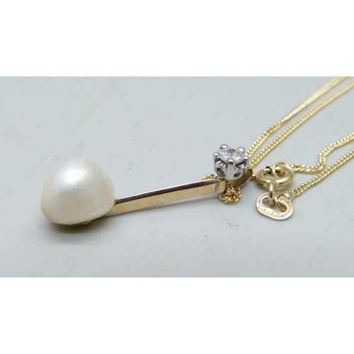 1059 - A natural saltwater pearl and diamond set in a yellow metal pendant with a white metal bail, on an 1... 