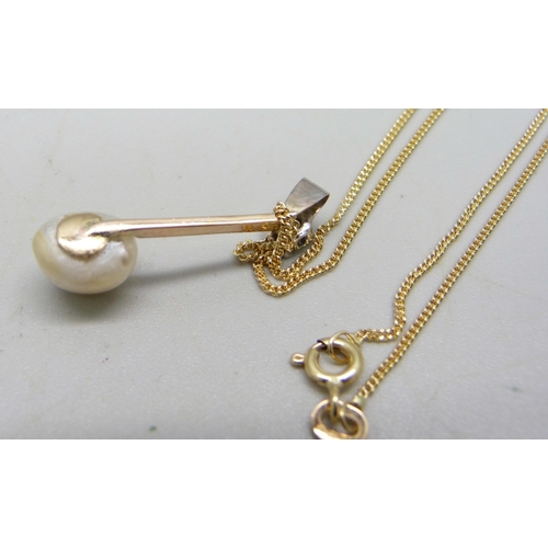 1059 - A natural saltwater pearl and diamond set in a yellow metal pendant with a white metal bail, on an 1... 