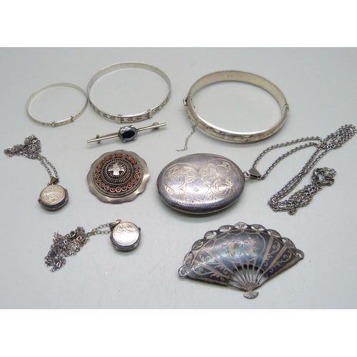 1083 - A large silver locket, 5x3.8 cm, three silver bangles, a Siam niello silver fan brooch, three silver... 