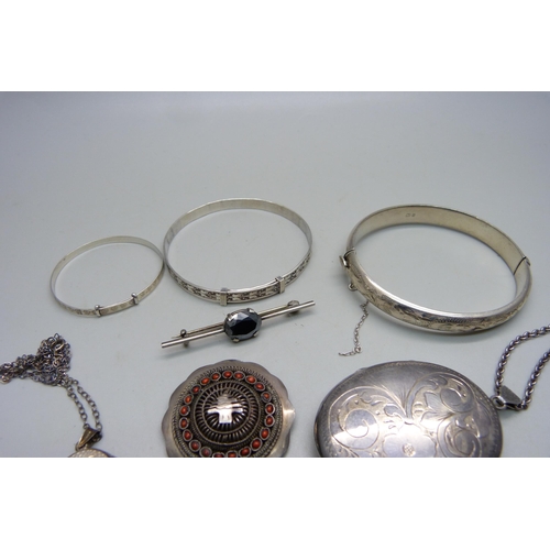 1083 - A large silver locket, 5x3.8 cm, three silver bangles, a Siam niello silver fan brooch, three silver... 