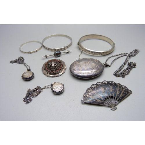 1083 - A large silver locket, 5x3.8 cm, three silver bangles, a Siam niello silver fan brooch, three silver... 