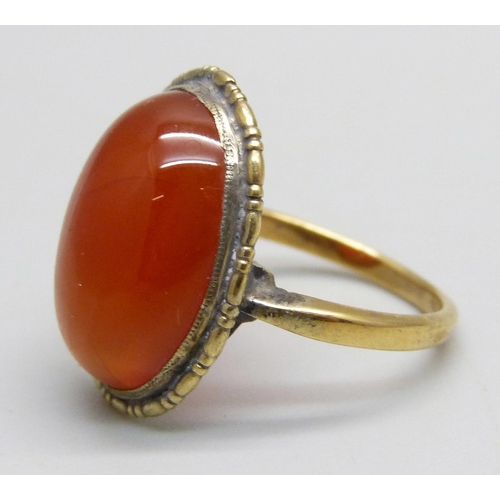 1099 - A yellow metal ring set with a cabochon chalcedony stone, 3.8g, N