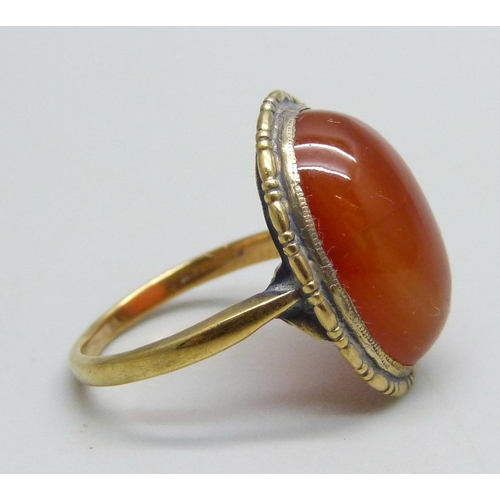 1099 - A yellow metal ring set with a cabochon chalcedony stone, 3.8g, N