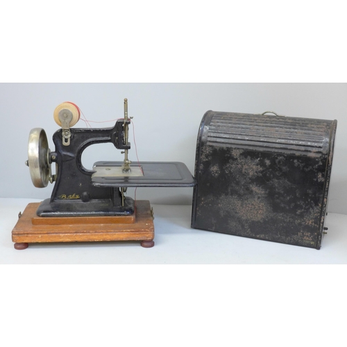 686 - An early child's sewing machine in tin holder, in working order