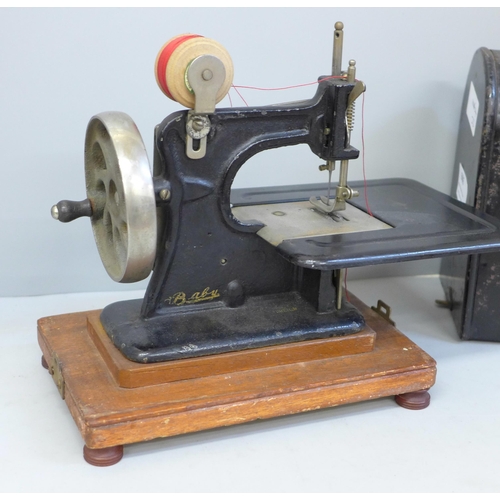 686 - An early child's sewing machine in tin holder, in working order