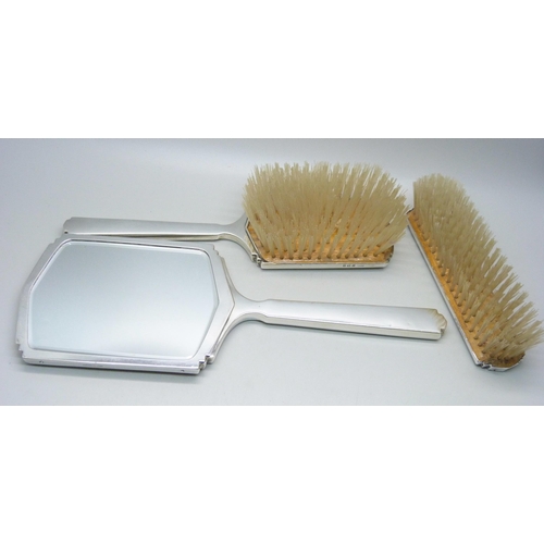 843 - A three piece silver vanity set, hand mirror and two hair brushes, Birmingham 1951