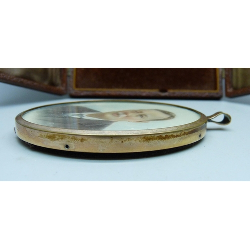 866 - A miniature oval portrait, in gold plated frame and set in a mount with back stand in a fitted case