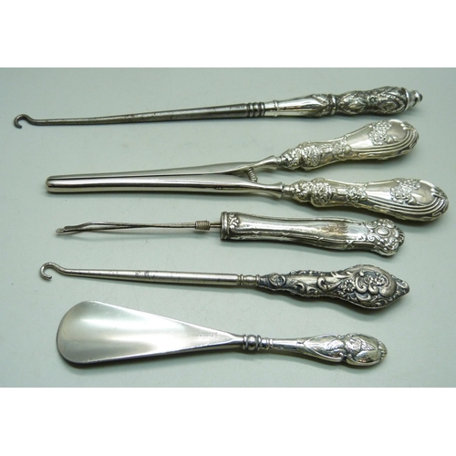 875 - Silver handled tools including one shoe horn decorated with Reynolds Angels