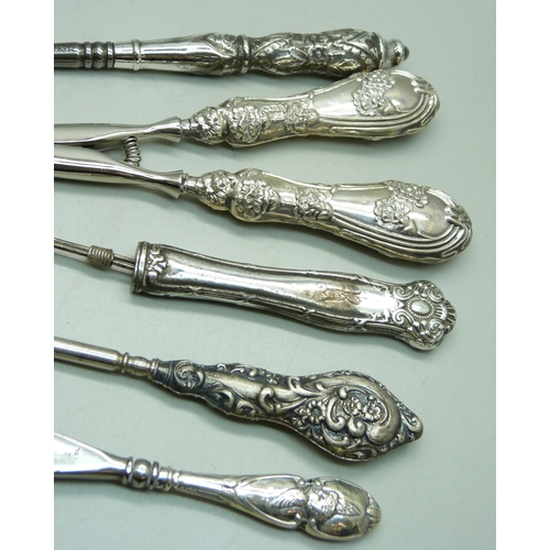 875 - Silver handled tools including one shoe horn decorated with Reynolds Angels