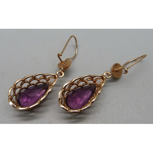 930 - A pair of yellow metal drop earrings set with pear cut purple stones, 4.3g, indistinct stamps to hoo... 