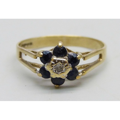 959 - A 9ct gold cluster ring set with a small central diamond and blue stones, 1.3g, K