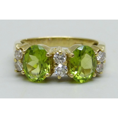 961 - An 18ct gold ring set with two peridot stones and six diamonds, 6.4g, P