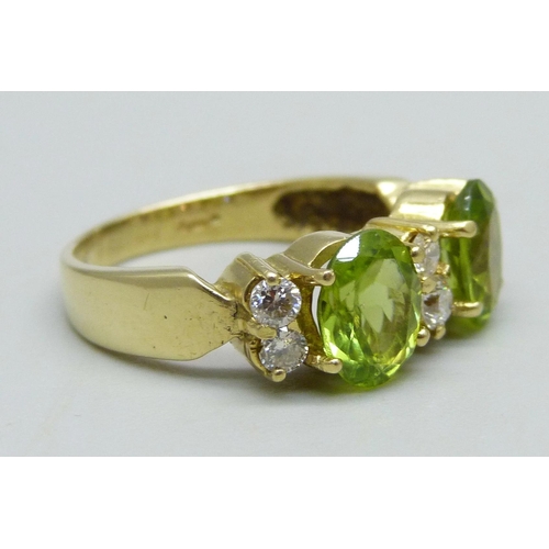 961 - An 18ct gold ring set with two peridot stones and six diamonds, 6.4g, P