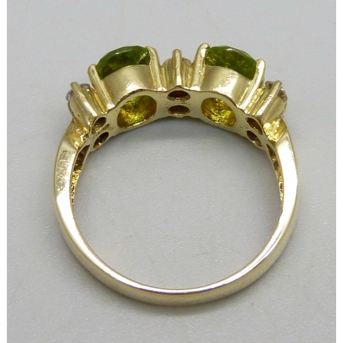 961 - An 18ct gold ring set with two peridot stones and six diamonds, 6.4g, P