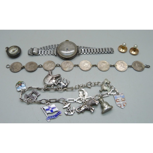 980 - A silver charm bracelet with silver and white metal charms, a silver cased wristwatch, a bracelet ma... 