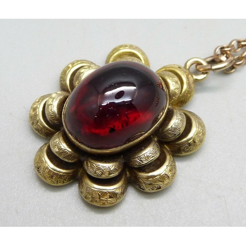 989 - An antique yellow metal pendant set with a cabochon garnet, on a 9ct gold chain, 3.2cm pendant, 66.5... 