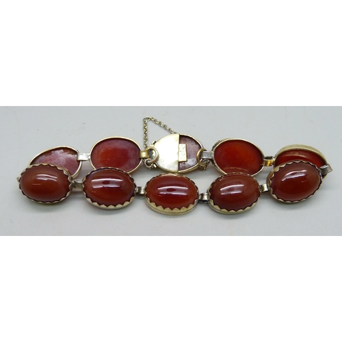 990 - A .900 silver gilt bracelet set with cabochon red stone panels, one setting a/f, 22g