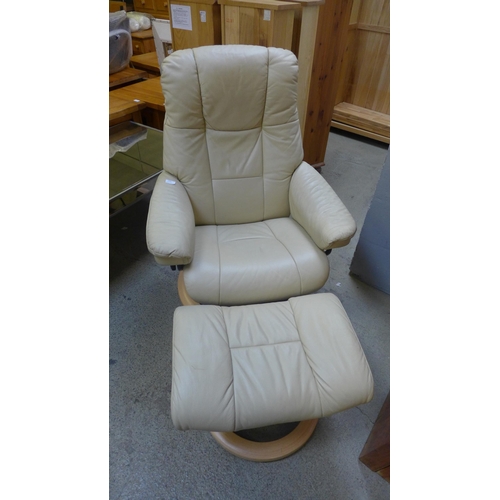 1554 - A cream leather Stressless armchair and stool