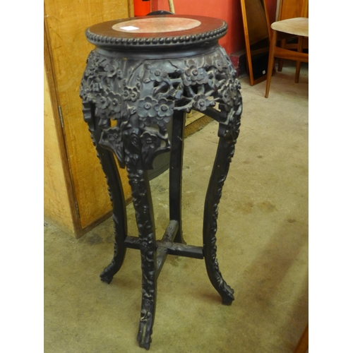 118A - A late 19th/early 20th Century carved hardwood and marble topped jardiniere stand