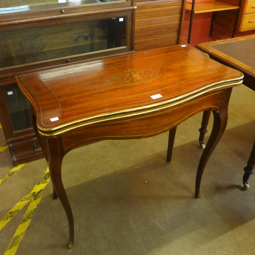 129 - A 19th Century mahogany and brass inlaid serpentine fold over games table