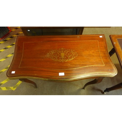 129 - A 19th Century mahogany and brass inlaid serpentine fold over games table