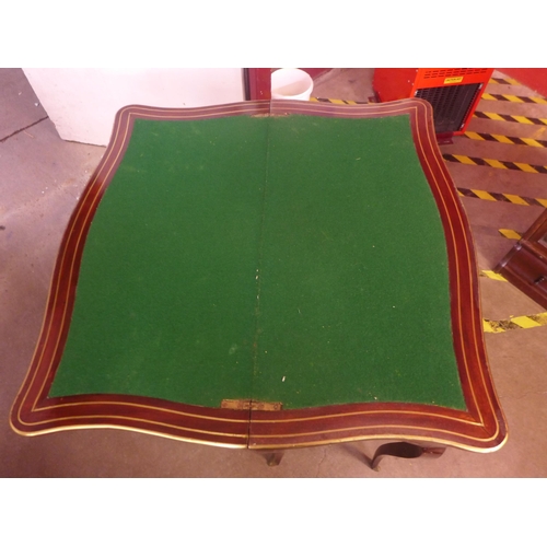 129 - A 19th Century mahogany and brass inlaid serpentine fold over games table