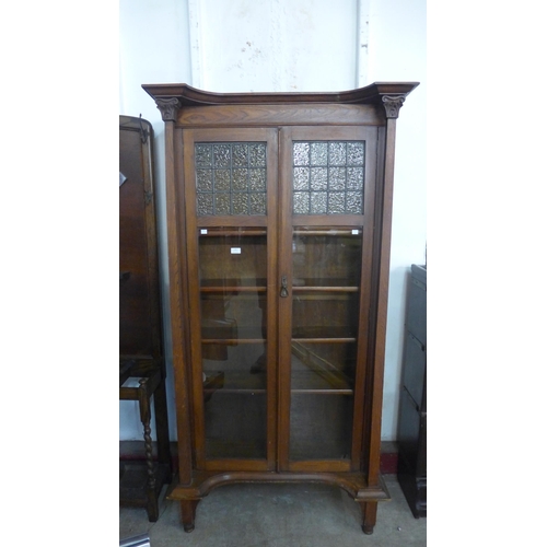 136 - An Arts and Crafts oak two door bookcase