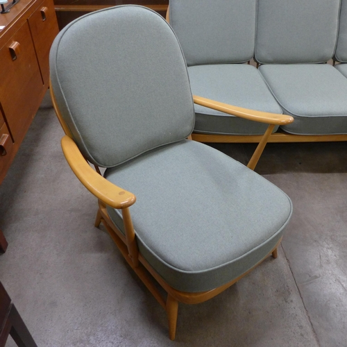 25 - An Ercol Blonde beech Windsor settee and a pair of armchairs, with new replacement sage wool fabric ... 