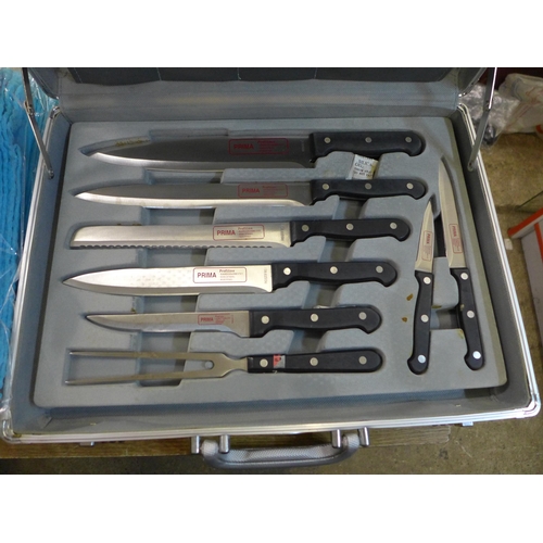 2133 - A cased set of Prima chef's knives, a set of prep bowls and ten tea towels