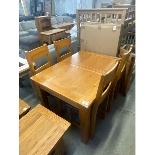 1571 - An oak extending dining table and a set of four dining chairs with leather seats