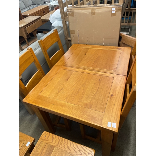 1571 - An oak extending dining table and a set of four dining chairs with leather seats