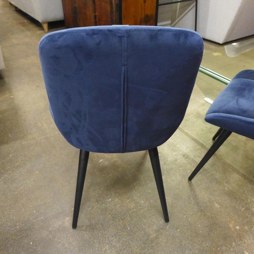 1365 - A pair of blue velvet upholstered dining chairs on black legs * this lot is subject to VAT