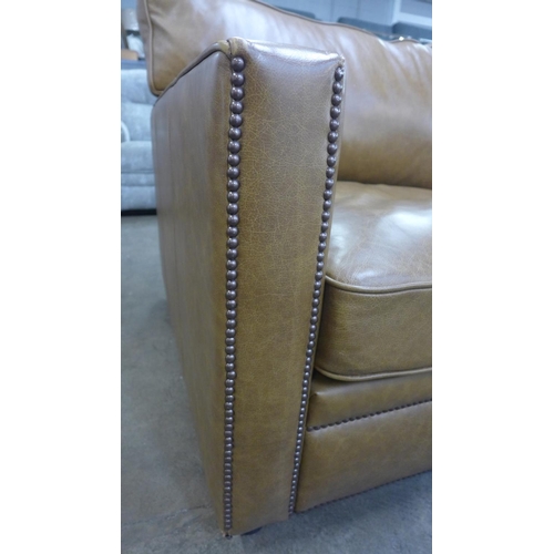 1490 - A tan vintage leather two and a half seater sofa with studwork, RRP £2850 * this lot is subject to V... 