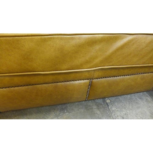 1490 - A tan vintage leather two and a half seater sofa with studwork, RRP £2850 * this lot is subject to V... 