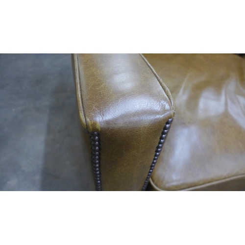 1490 - A tan vintage leather two and a half seater sofa with studwork, RRP £2850 * this lot is subject to V... 