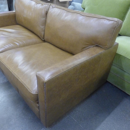 1490 - A tan vintage leather two and a half seater sofa with studwork, RRP £2850 * this lot is subject to V... 