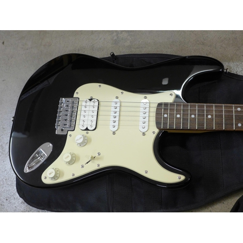 858 - A Fender Squier Stratocaster electric guitar, black, with Vox plug in headphone amp, digital tuner, ... 