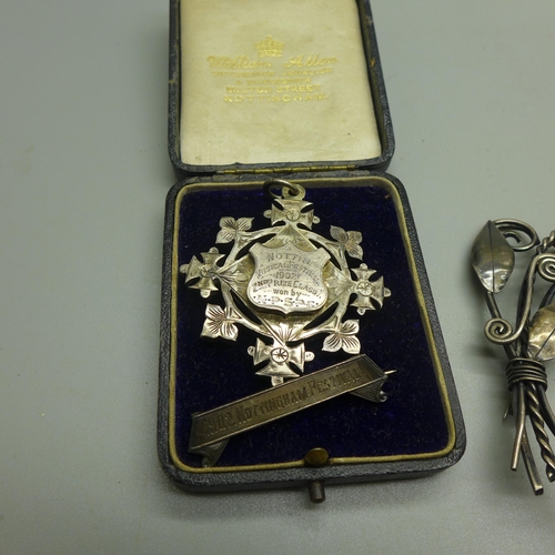 917 - Three silver brooches and a silver conductors fob medal, 71g