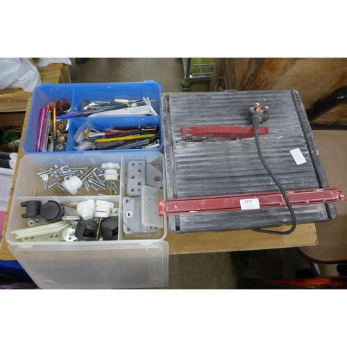 2379 - A tile cutter, casters, nuts, bolts, pens, etc.