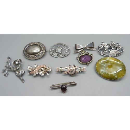 1044 - Three silver brooches including one with a ceramic plaque stamped 'Astra', white metal brooches and ... 