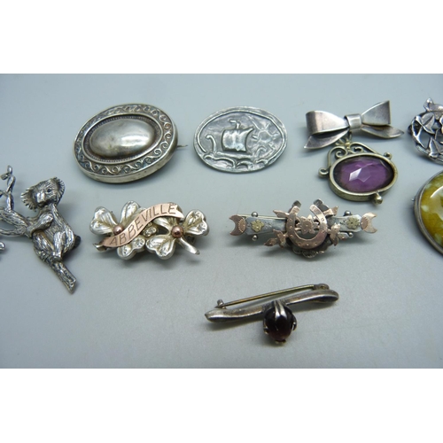 1044 - Three silver brooches including one with a ceramic plaque stamped 'Astra', white metal brooches and ... 