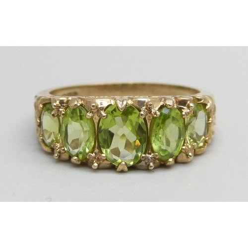 1047 - A 9ct gold ring set with five peridot stones, 3.7g, Q