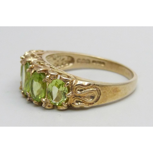 1047 - A 9ct gold ring set with five peridot stones, 3.7g, Q