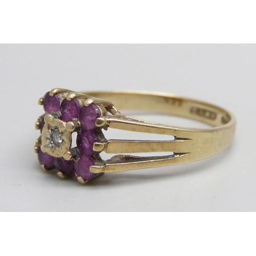 1050 - A 9ct gold ring set with purple stones and a central diamond, 2.5g, R, (two stones darker - possibly... 