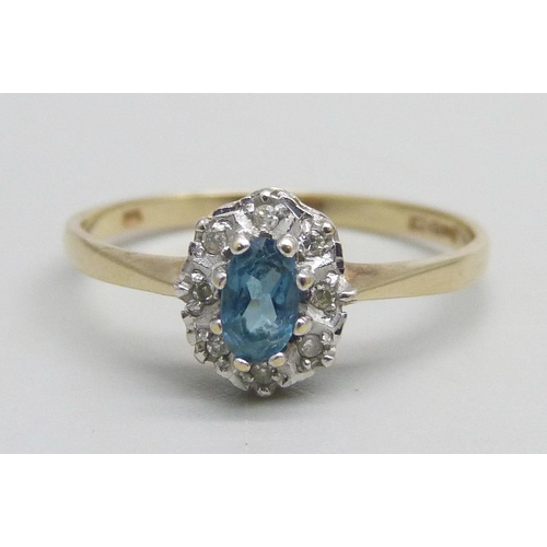 1054 - A 9ct gold ring set with a central blue stone and diamond halo, 1.3g, N