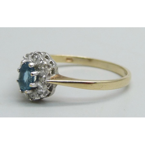 1054 - A 9ct gold ring set with a central blue stone and diamond halo, 1.3g, N