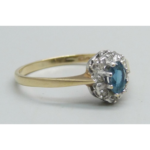 1054 - A 9ct gold ring set with a central blue stone and diamond halo, 1.3g, N