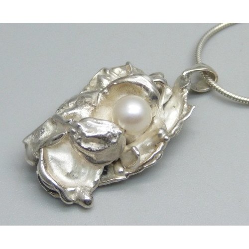 1094 - A modern water-cast silver pendant by Andrew Elliott, assayed for maker and set with a cultured pear... 