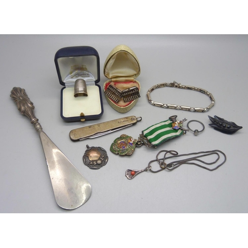 1102 - A collection of silver including a penknife, a thimble, a shoe horn with silver handle, a pair of cu... 