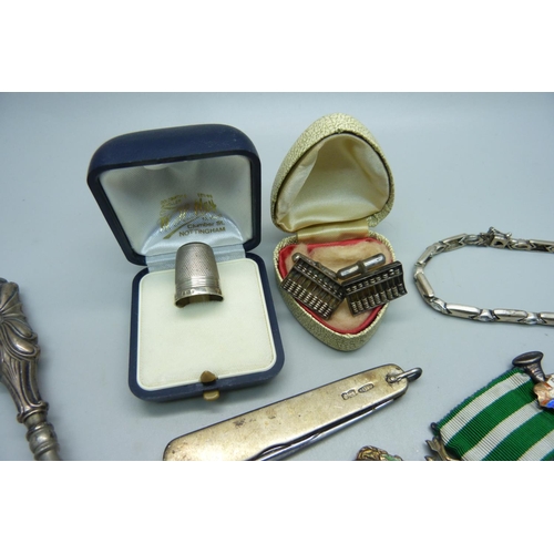 1102 - A collection of silver including a penknife, a thimble, a shoe horn with silver handle, a pair of cu... 